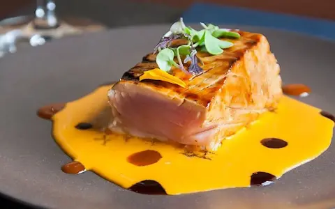 Un delicioso atún sellado sobre una cremosa salsa de naranja, perfecto para comer en Cambados.