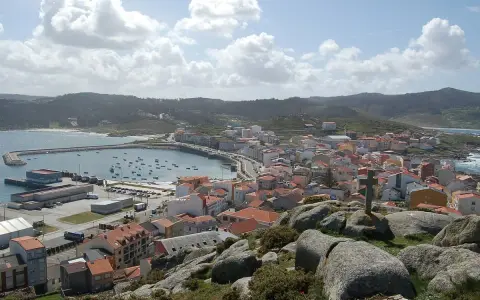 Vista panorámica de Muxía, con su puerto y casas de tejados rojos. Un lugar perfecto para comer y disfrutar del paisaje.