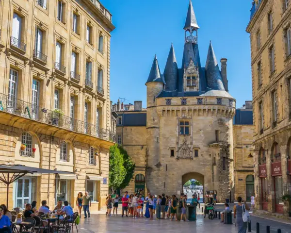 La Porte Cailhau y edificios históricos en Burdeos. Un lugar ideal que ver en Burdeos, con gente paseando y terrazas.