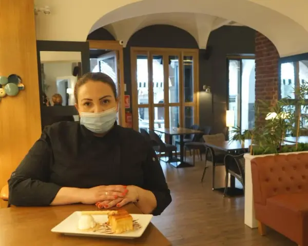 Chef con mascarilla en un restaurante moderno, ideal para saber donde comer en Zafra. Postre en primer plano.
