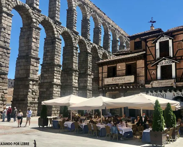 Mesón de Candido, un lugar ideal donde comer en Segovia, bajo el imponente acueducto. Mesas al aire libre.