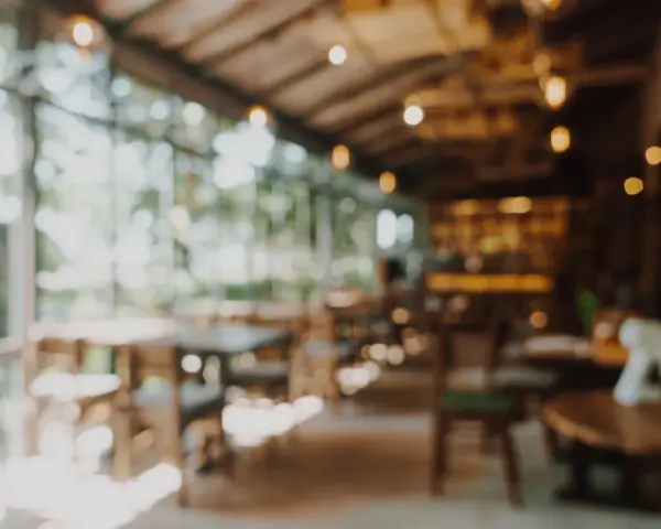 Ambiente acogedor para comer en Gandía, con mesas de madera y luces cálidas.