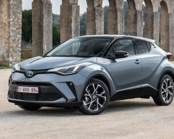 Toyota C-HR gris, un coche ideal para quienes buscan coches baratos de mantener, aparcado frente a un acueducto.