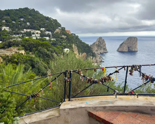 Vista de los Faraglioni, un clásico que ver en Capri. El balcón está adornado con candados de amor.