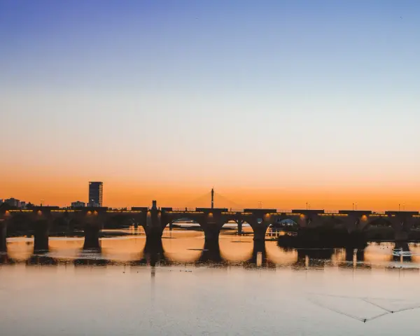 Atardecer sobre el río Guadiana, con el Puente de Palmas iluminado. Un paisaje idílico para descubrir qué ver en Badajoz.