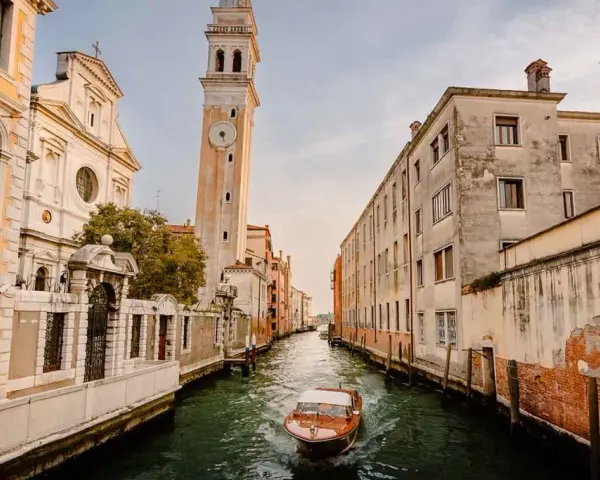 Un canal veneciano con un barco de madera y edificios antiguos. ¿Cuántos días para ver Venecia?