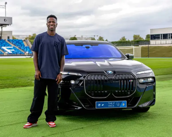Vinícius Jr. posa junto a un BMW eléctrico en Madrid, disfrutando de las ventajas de un coche eléctrico en la ciudad.