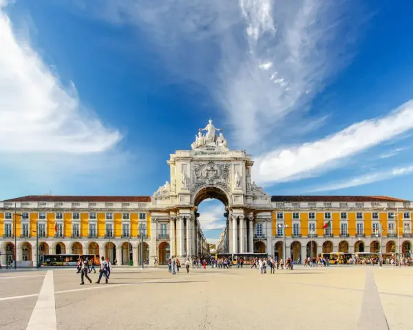 Arco da Rua Augusta y Praça do Comércio, un lugar ideal que ver en Lisboa en 3 días. Gente paseando bajo el cielo azul.