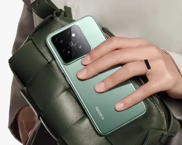Mano con anillo sostiene un teléfono verde con cámara Leica, ideal para tus aplicaciones para viajar y capturar recuerdos.