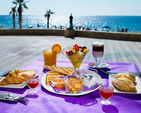 Desayuno frente al mar en Calpe: cruasanes, tostadas, fruta fresca, yogur y café. ¡Un lugar ideal donde comer en Calpe!