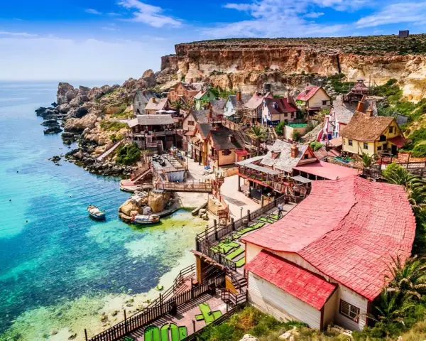 Un pintoresco pueblo de pescadores en Malta en verano, con casas coloridas y aguas turquesas.