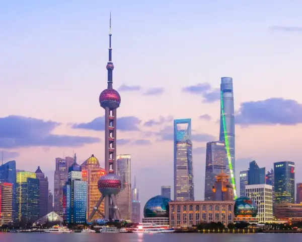 El horizonte de Shanghái al atardecer, con la Torre de la Perla Oriental y rascacielos iluminados. Un sueño para un viaje a China 10 días.