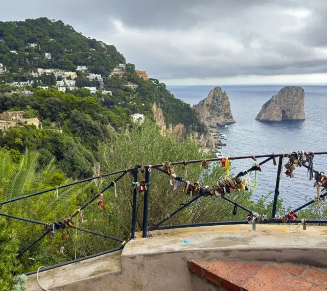Vista de los Faraglioni, un clásico que ver en Capri. El balcón está adornado con candados de amor.
