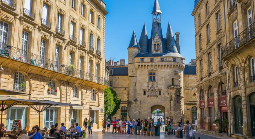 La Porte Cailhau y edificios históricos en Burdeos. Un lugar ideal que ver en Burdeos, con gente paseando y terrazas.