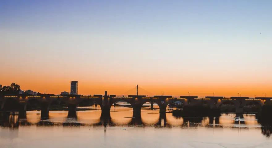 Atardecer sobre el río Guadiana, con el Puente de Palmas iluminado. Un paisaje idílico para descubrir qué ver en Badajoz.