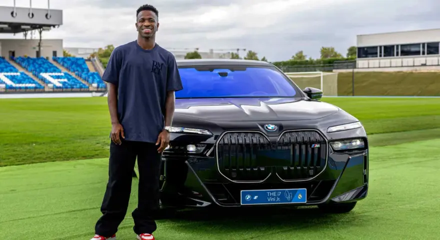 Vinícius Jr. posa junto a un BMW eléctrico en Madrid, disfrutando de las ventajas de un coche eléctrico en la ciudad.