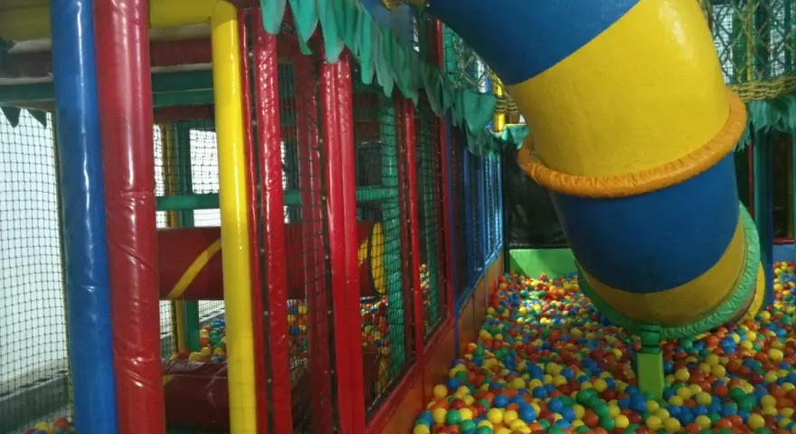 Parque infantil en Gijón con niños, perfecto para un día de lluvia. ¡A disfrutar de las bolas de colores!