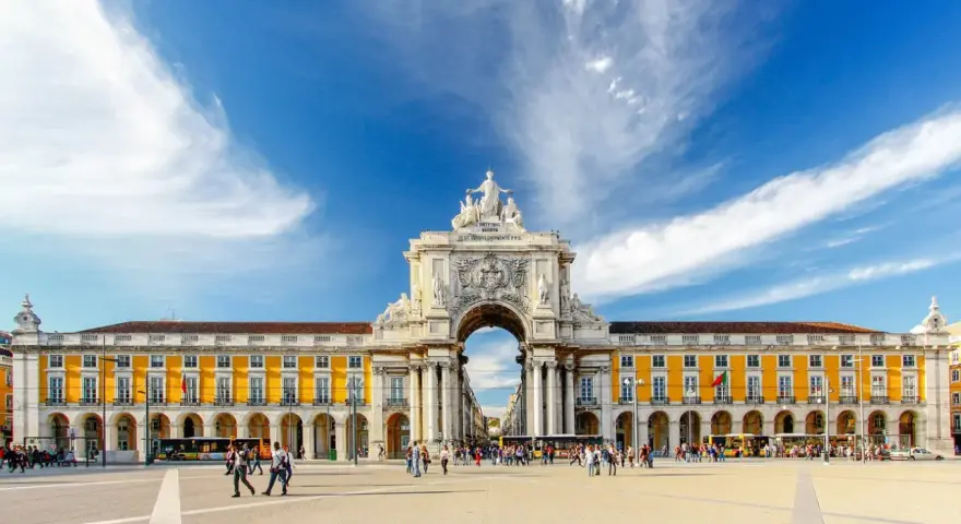 Arco da Rua Augusta y Praça do Comércio, un lugar ideal que ver en Lisboa en 3 días. Gente paseando bajo el cielo azul.