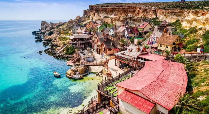 Un pintoresco pueblo de pescadores en Malta en verano, con casas coloridas y aguas turquesas.