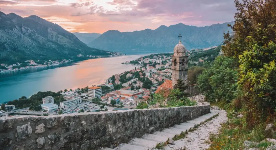 Vista de Kotor, Montenegro, al atardecer. Un lugar ideal donde viajar en julio barato, con vistas a la bahía y montañas.