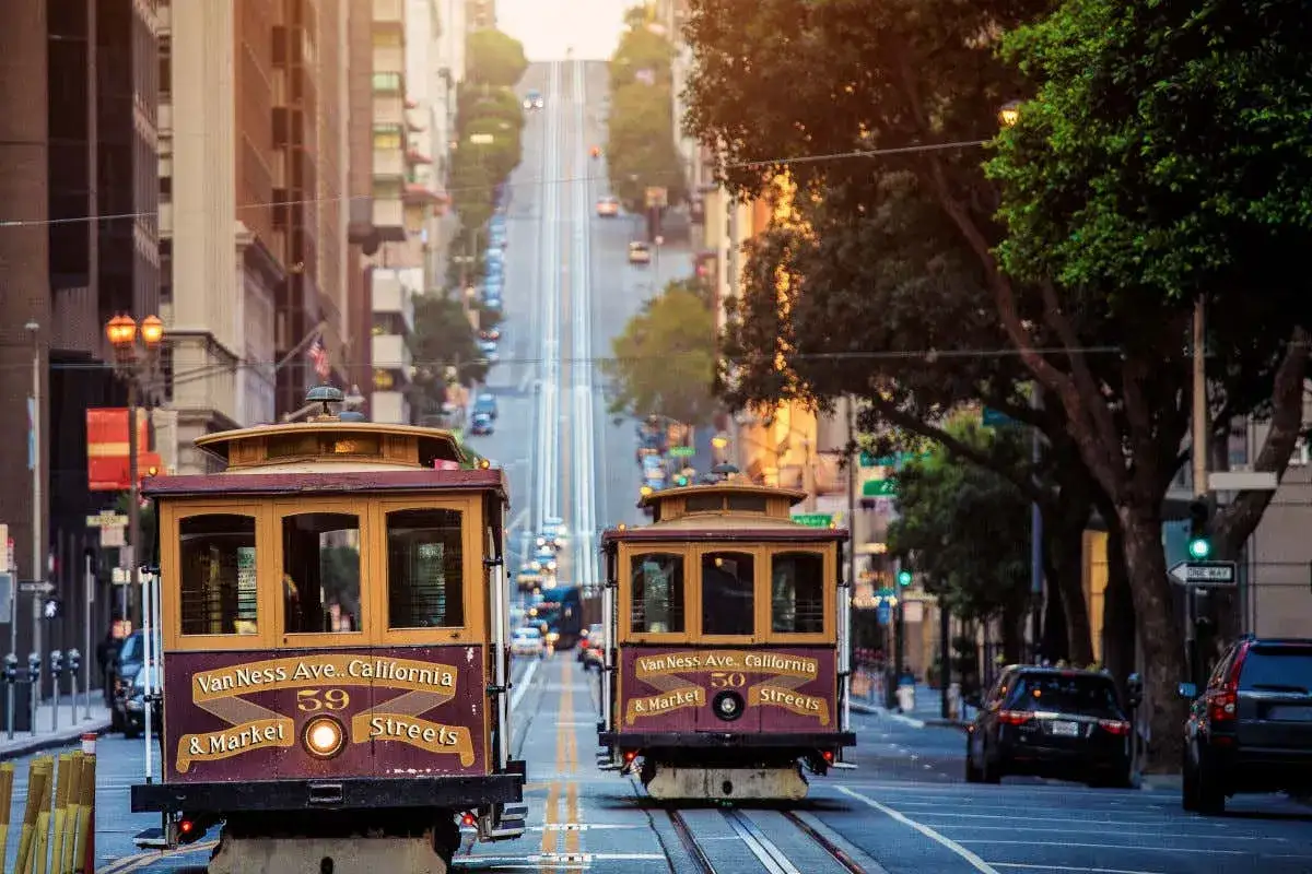Tranvías icónicos subiendo una colina empinada, una vista clásica de qué ver en San Francisco.