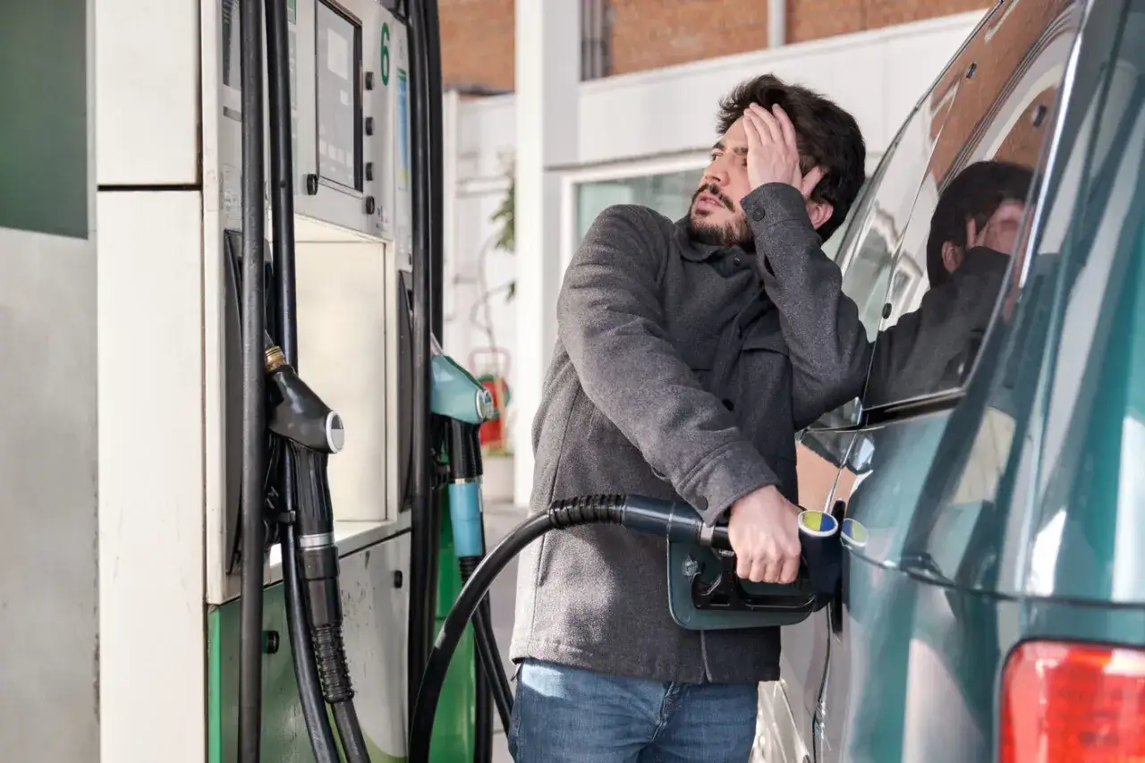Hombre frustrado en gasolinera, &iquest;c&oacute;mo saber si un coche es gasolina o di&eacute;sel? La manguera de combustible en el coche.