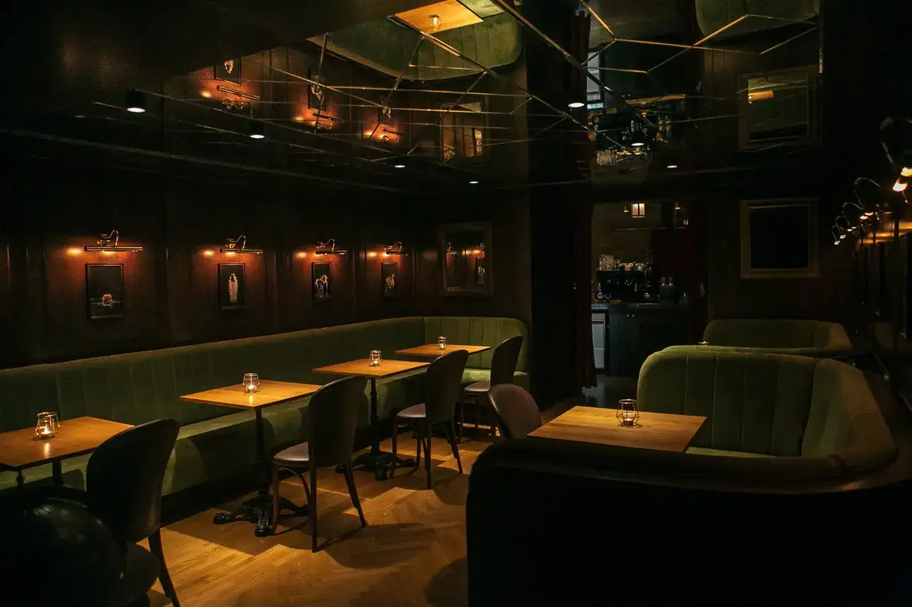 Ambiente &iacute;ntimo para comer en Budapest. Sof&aacute;s verdes, mesas de madera y luces c&aacute;lidas crean un espacio acogedor.