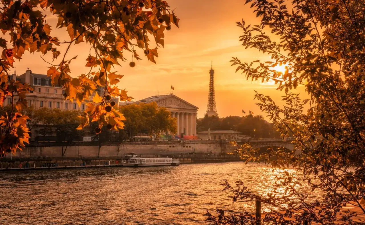 Atardecer dorado sobre el Sena, con la Torre Eiffel y edificios hist&oacute;ricos. Ideal para planificar qu&eacute; ver en Par&iacute;s en 2 d&iacute;as.