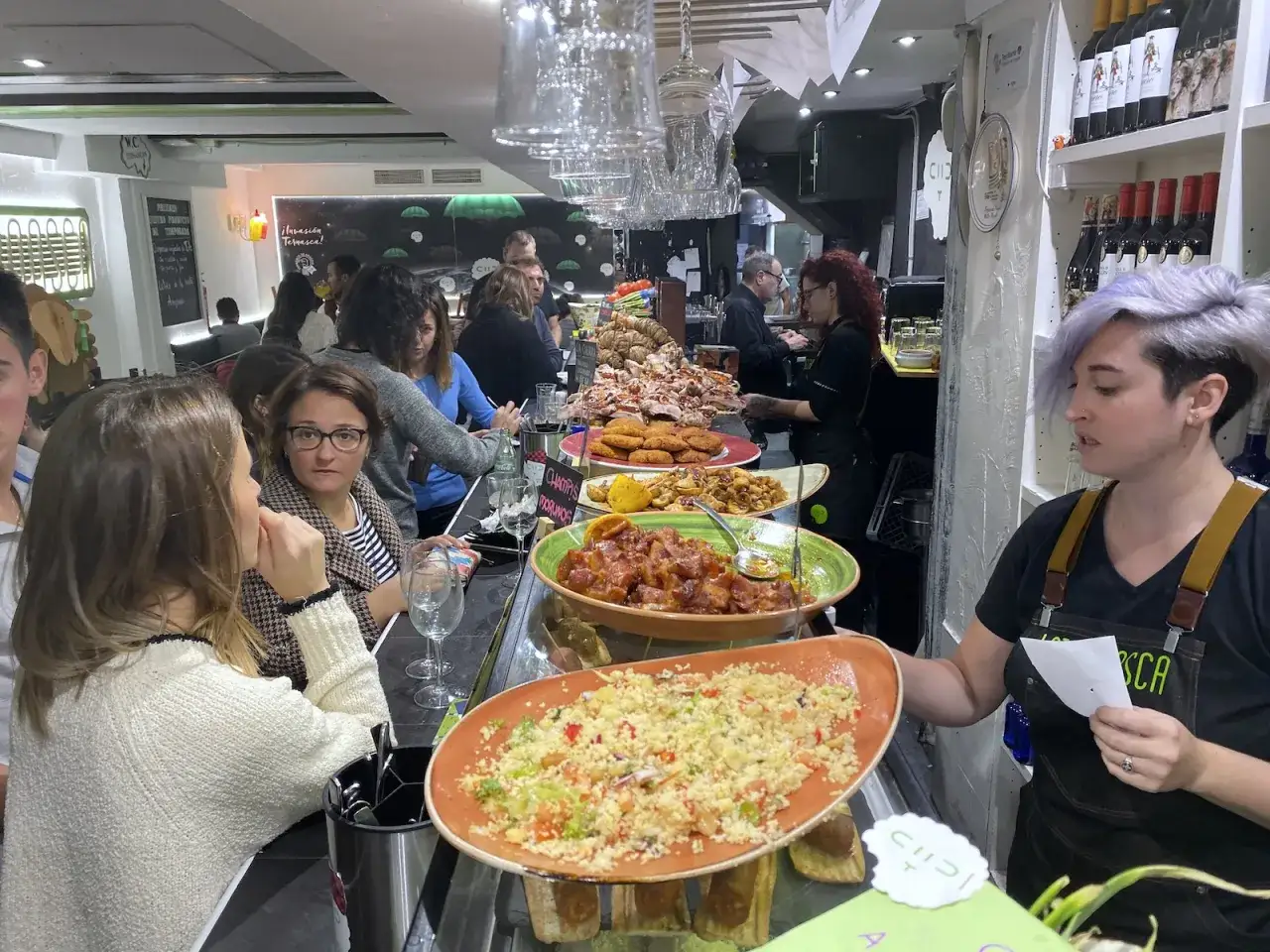 Gente disfrutando de tapas y comida en un bar, una excelente opci&oacute;n de donde comer en Zaragoza.