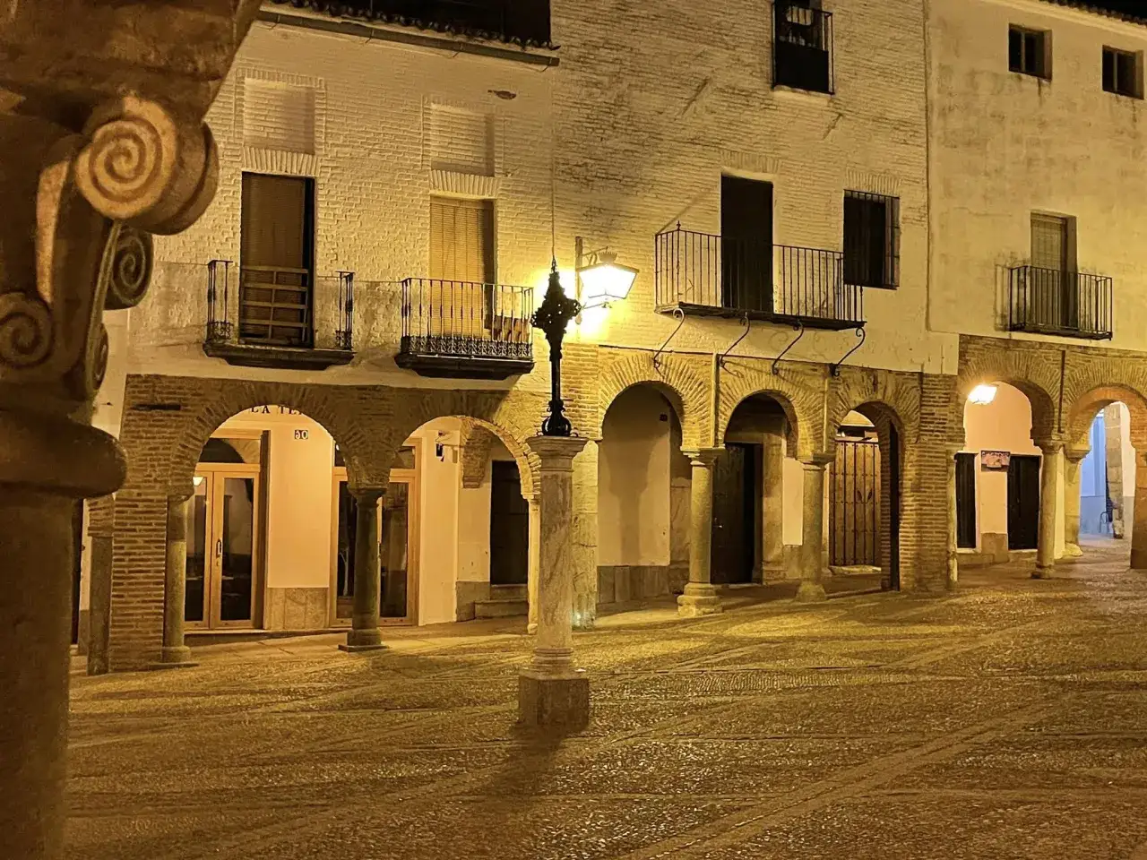 Plaza de Zafra de noche, con soportales, farola y suelo empedrado. Un lugar con encanto que ver en Zafra.