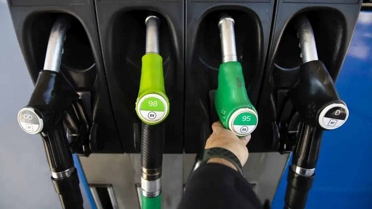 Mangueras de gasolina y di&eacute;sel en una gasolinera. La mano elige entre 95 y 98 octanos, comparando el precio gasolina vs diesel.