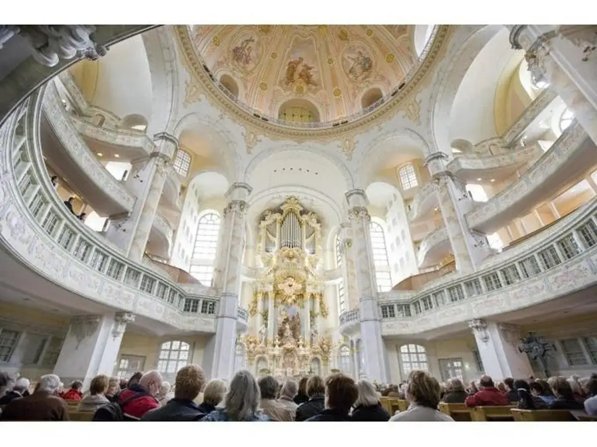Interior de la Frauenkirche, Dresde. Un grupo de personas asiste a visitas guiadas dresden, admirando el órgano y la cúpula.