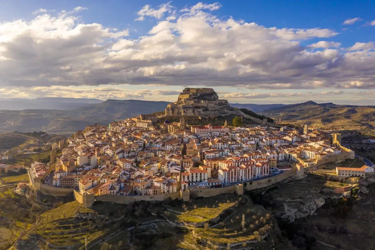 Vista a&eacute;rea de Morella, un pueblo amurallado con un castillo imponente. Descubre qu&eacute; ver en Morella, un lugar m&aacute;gico.