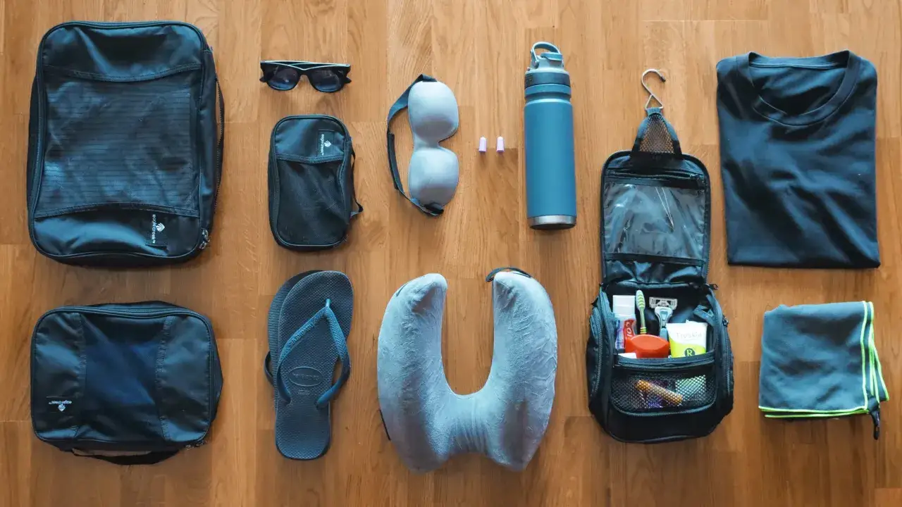 Lista de art&iacute;culos esenciales para llevar a Tailandia: neceser, chanclas, almohada de viaje, gafas de sol, botella de agua, camiseta y toalla.