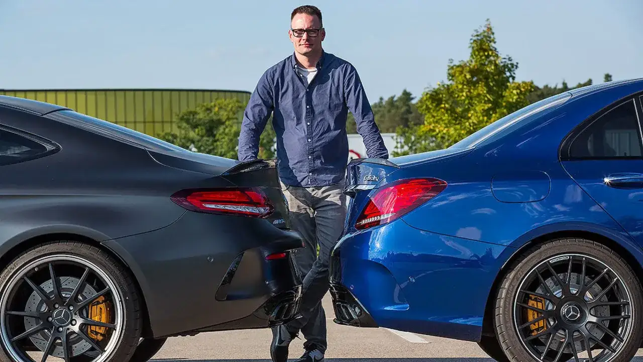 Hombre entre un coche azul y uno gris oscuro, mostrando la diferencia entre berlina y coup&eacute;.