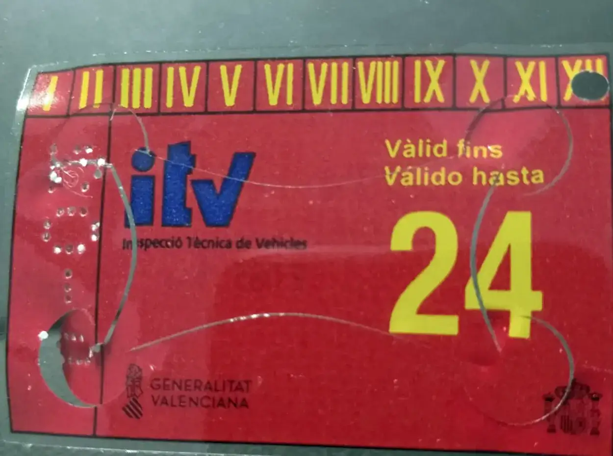 Pegatina ITV roja con el logo de ITV y el número 24. Indica 