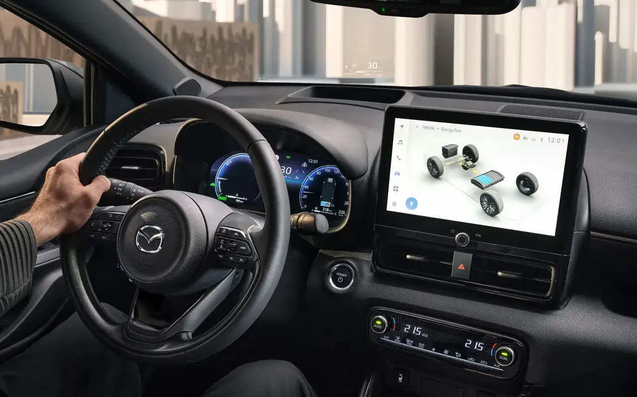 Interior de un coche h&iacute;brido autom&aacute;tico. Se ve el volante, la pantalla t&aacute;ctil mostrando el flujo de energ&iacute;a y el panel de control.