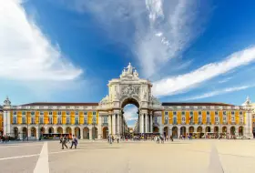 Arco da Rua Augusta y Praça do Comércio, un lugar ideal que ver en Lisboa en 3 días. Gente paseando bajo el cielo azul.
