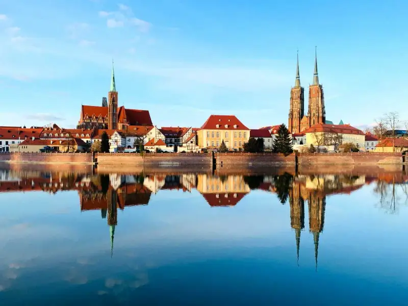 Imponente skyline de Breslavia, Polonia, con sus iglesias y edificios históricos reflejados en el sereno río Odra.