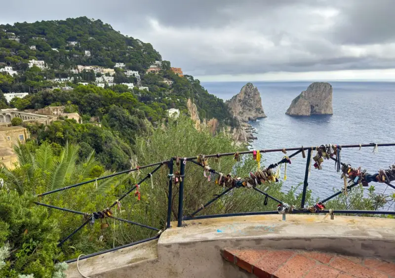Vista de los Faraglioni, un clásico que ver en Capri. El balcón está adornado con candados de amor.