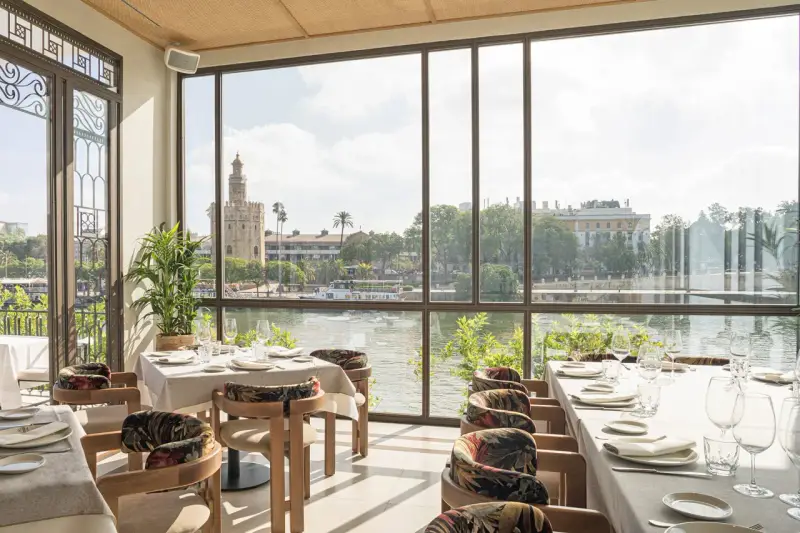 Mesas puestas con vistas a la Torre del Oro. Un lugar ideal donde comer en Sevilla.